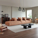 "Modern living room with a brown sectional sofa, coffee table, and decorative items."