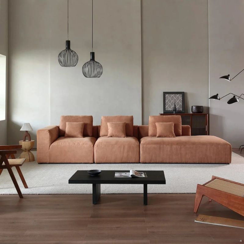 "Modern living room with a brown sofa, black coffee table, and decorative items."