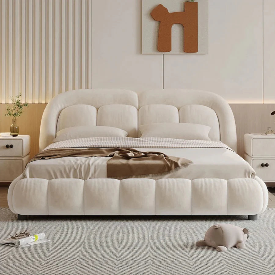 "Beige upholstered bed in a modern bedroom setting with minimal decor."