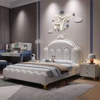 "Modern bedroom with a white bed, desk, and decorative wall lights."