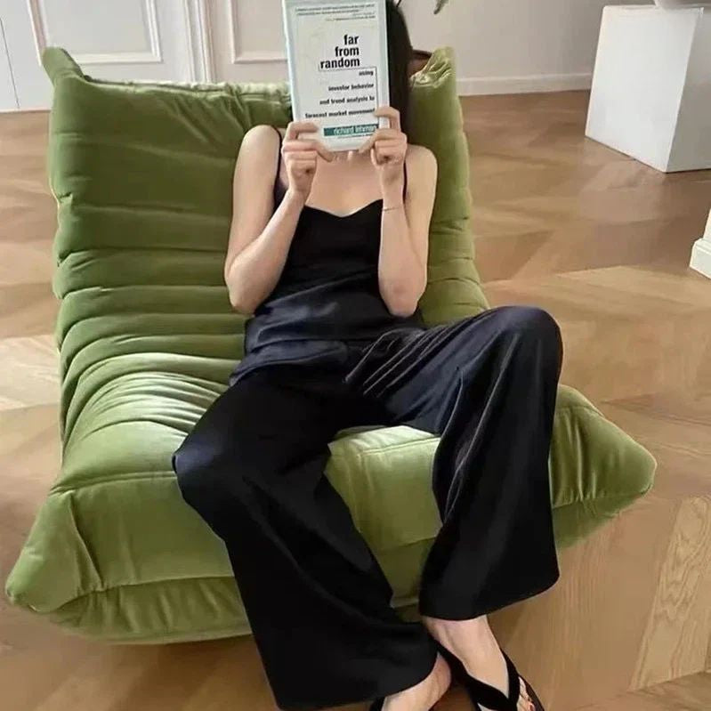 "Person sitting on a green couch holding a book titled 'far from random'."