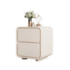 "Beige nightstand with decorative items on a white background"