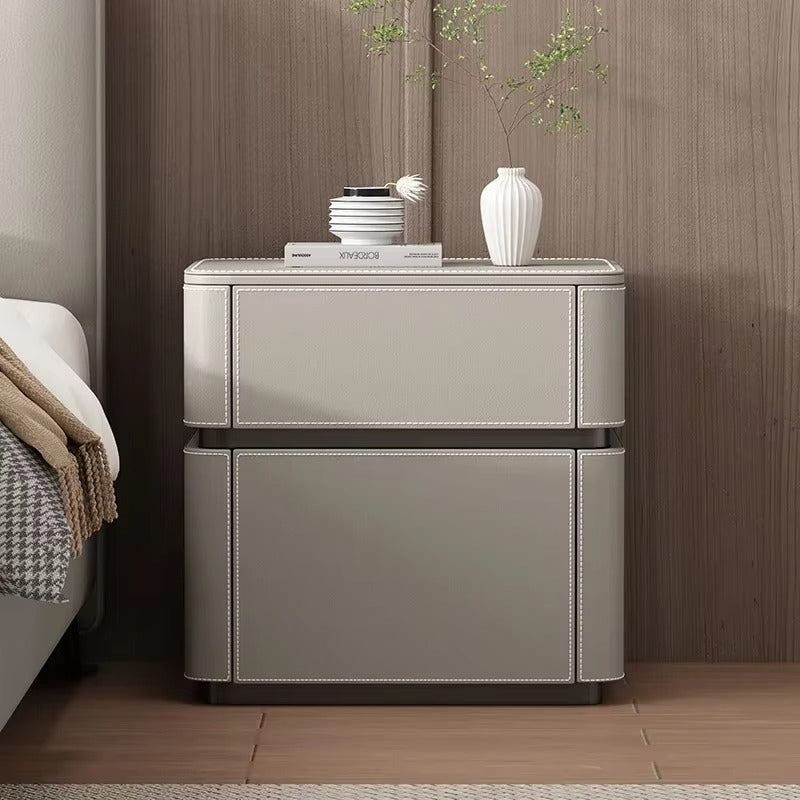 "Beige nightstand with decorative items against a wooden wall"
