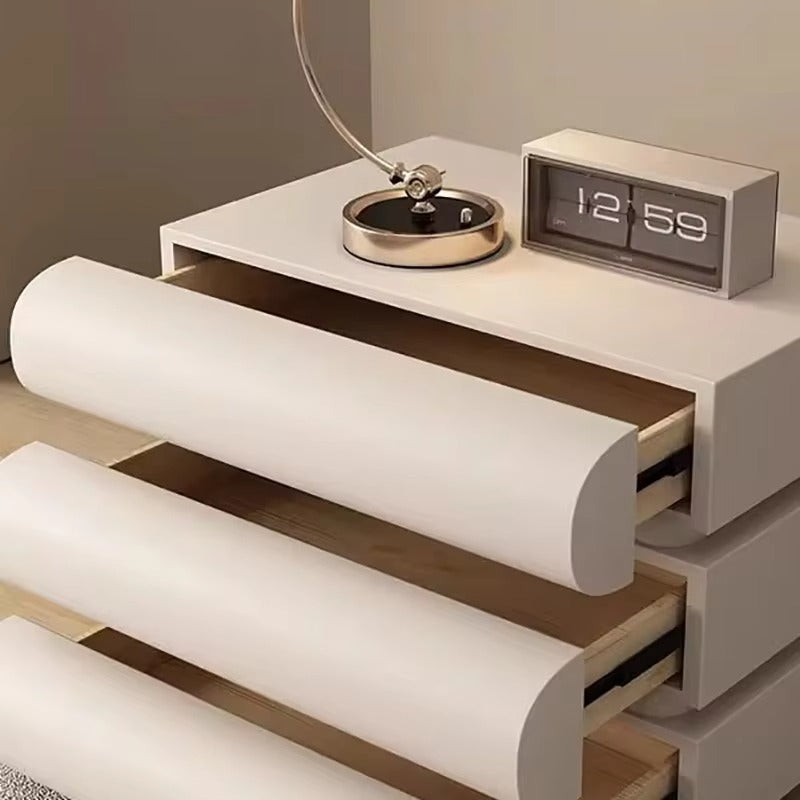 "Modern nightstand with clock, lamp, and rolled-up paper on a neutral background"