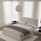"Modern bedroom with a bed, side tables, and curtains."
