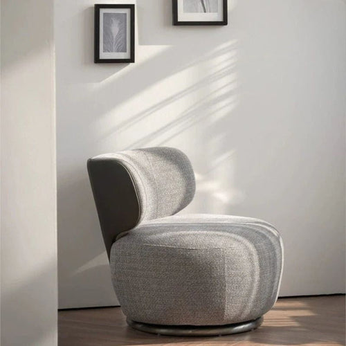 "Gray modern chair in a minimalistic room with light-Advanced Swivel Lazy Leisure Chair Made with Fabric. colored walls and wooden floor."