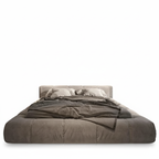 Gray bed with matching bedding on a white background. Velvet bedframe, velvet king bed. 