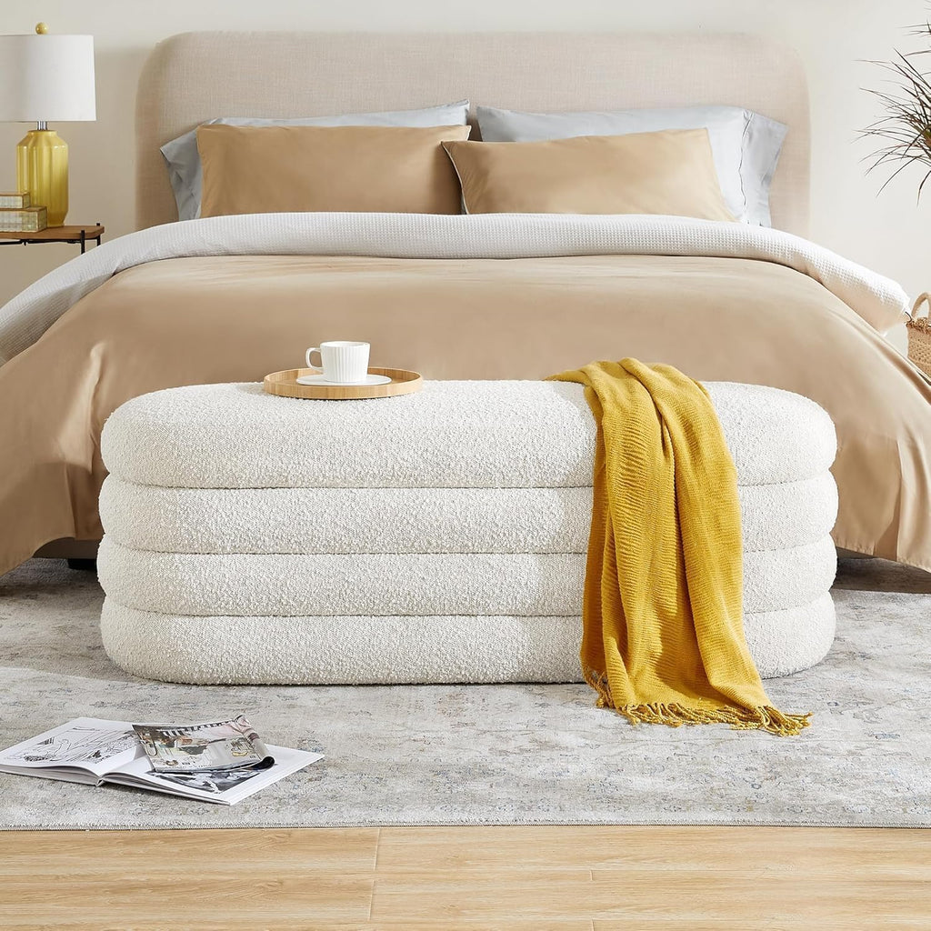 Stack of folded towels with a yellow towel draped over them next to a neatly made bed. Storage bench for bedroom, Outdoor storage bench, Entryway bench with storage.
