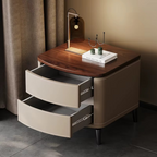 Modern nightstand with wooden top and curved drawers in a dimly lit room.