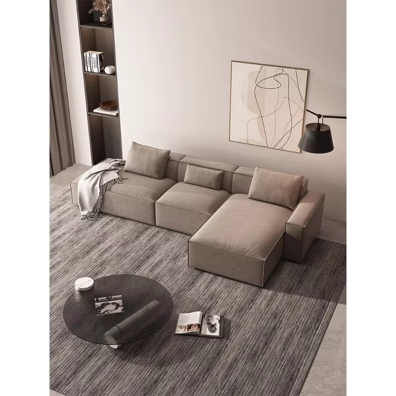 Modern living room with a gray sectional sofa, round glass coffee table, and abstract art on the wall. Sleeper sofa, Sectional sofa, Living room sofa. 