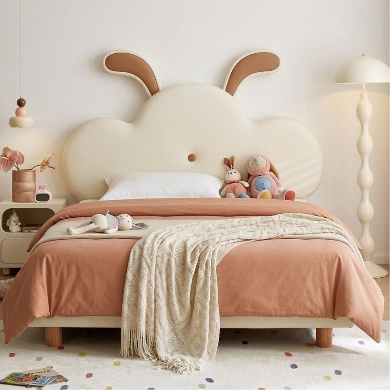 Children's bedroom with a cloud-shaped headboard and pink bedding.