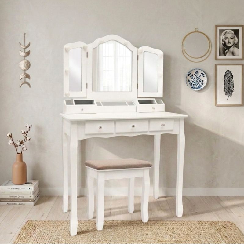 White vanity table with mirror and stool in a room setting 