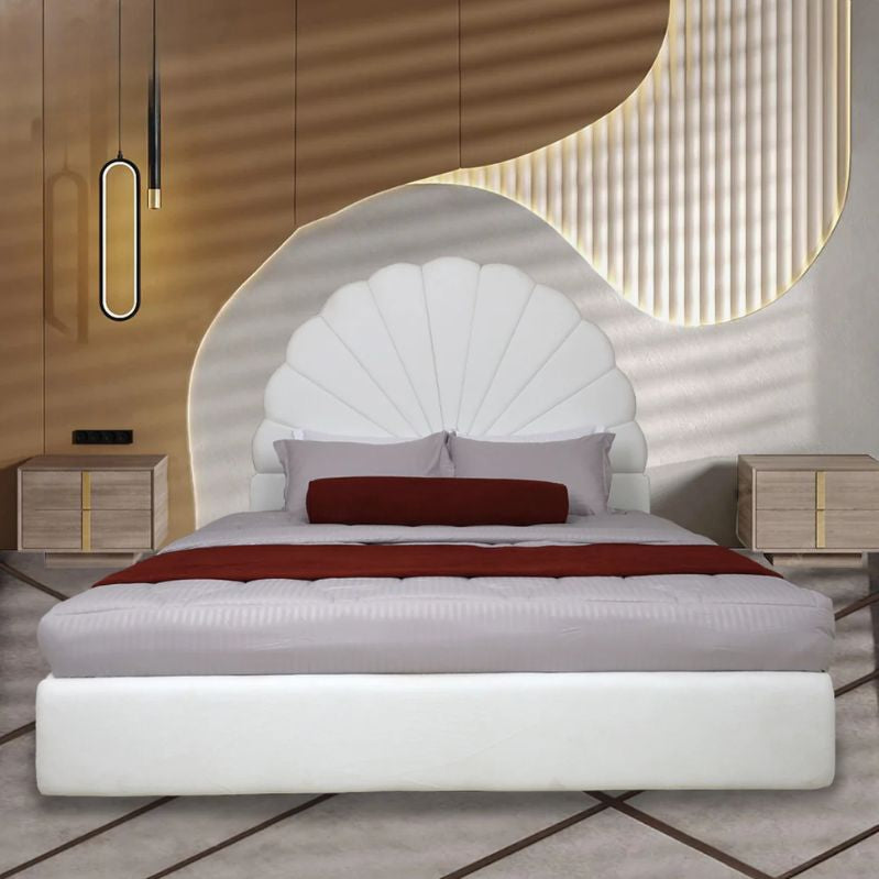 Modern bedroom with a white upholstered bed and decorative headboard. 