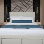 Modern bedroom with a bed featuring white bedding and blue accent pillows, against a decorative wall. 