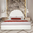 Modern bedroom with a white upholstered bed, red blanket, and stone wall art.