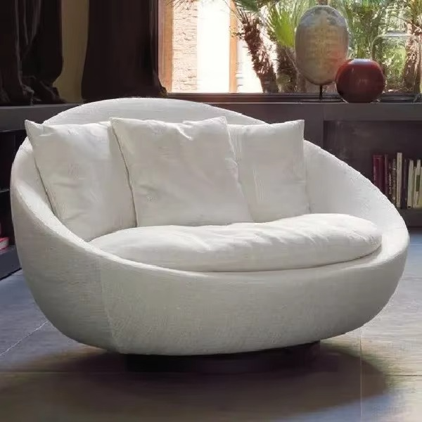 Modern white sofa in a room with a window and decorative items. Living room chair, Outdoor furniture, Round minimalist chair. 