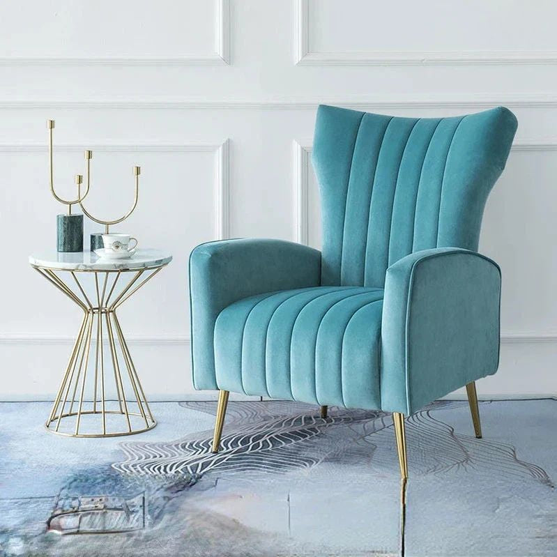 "Teal armchair with gold legs in a stylish room setting"