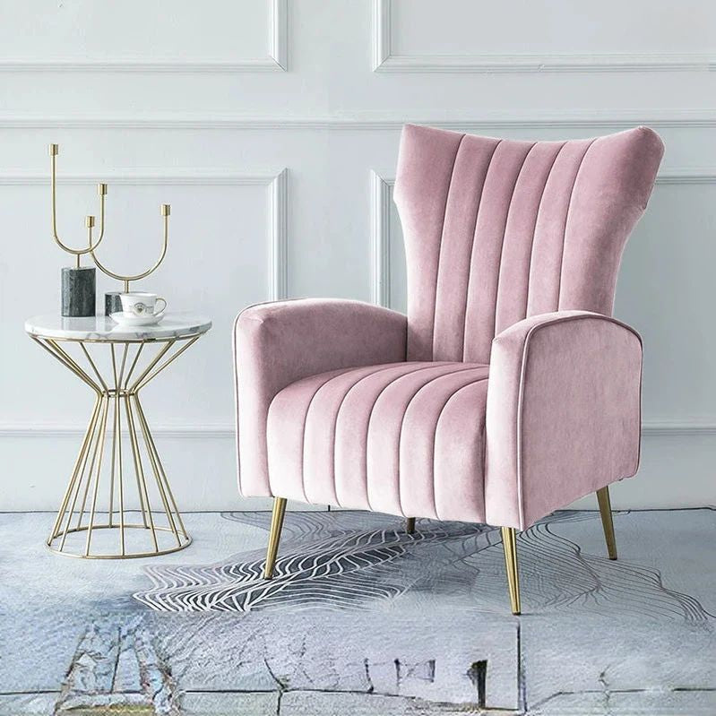 "Pink armchair in a stylish room with a side table and decor items."