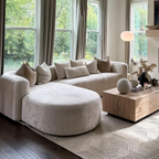 "Modern living room with a beige sectional sofa, round ottoman, and wooden coffee table."