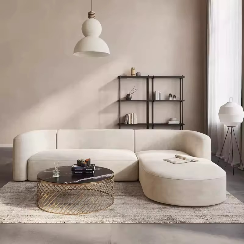 Modern living room with a white sectional sofa, coffee table, and decorative items. L-shape sofa, Velvet sofa, Living room sofa, Sectional sofa.