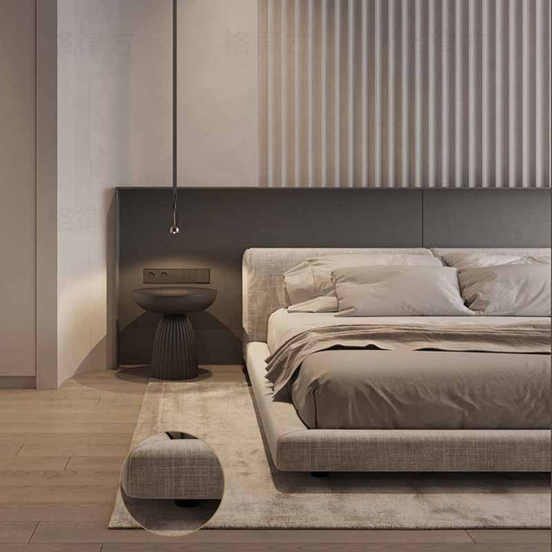 Modern bedroom with a gray upholstered bed and minimal decor.