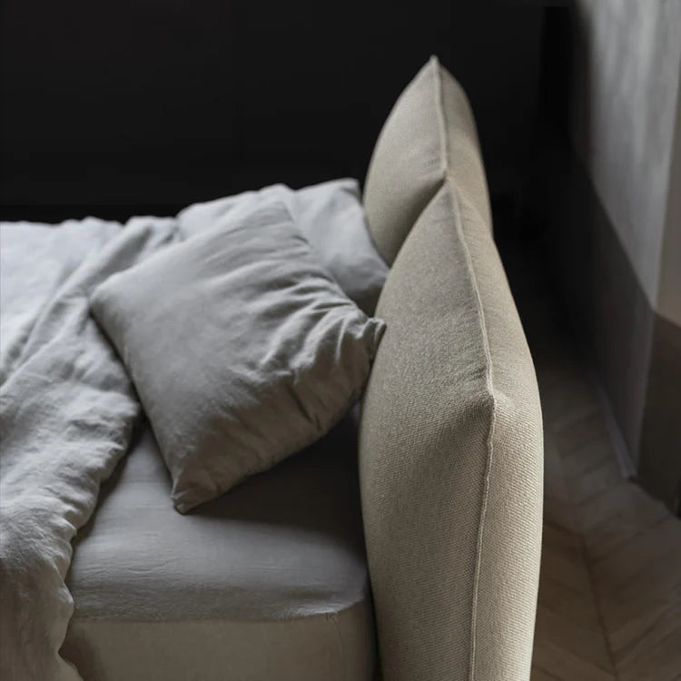 Beige sofa with pillows and a blanket in a softly lit room