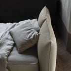 Beige sofa with pillows and a blanket in a softly lit room