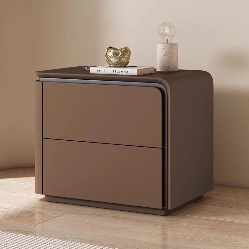 Brown nightstand with two drawers on a wooden floor against a beige wall.  