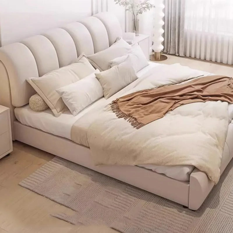 "Modern Upholstered Bed Frame. Neatly made bed with beige and white bedding in a bright bedroom."