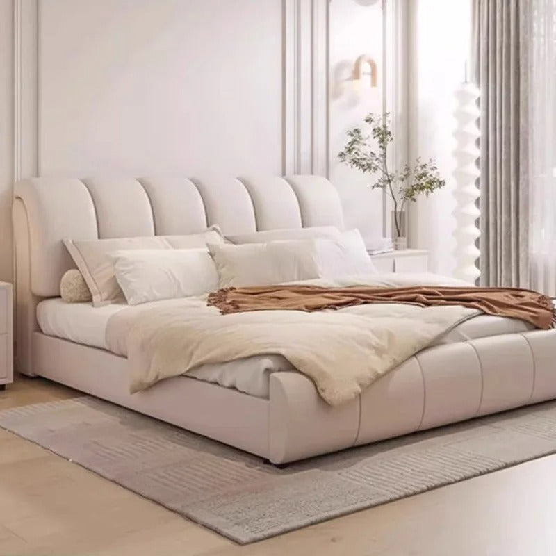"Modern Upholstered Bed Frame. Beige upholstered bed with white bedding and a blanket in a bright room."