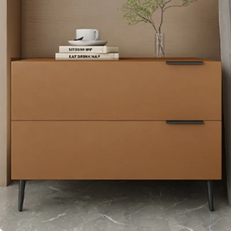 Brown dresser with books and a cup on top against a beige wall.