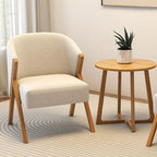 Beige armchair and wooden side table with a plant in a living room setting