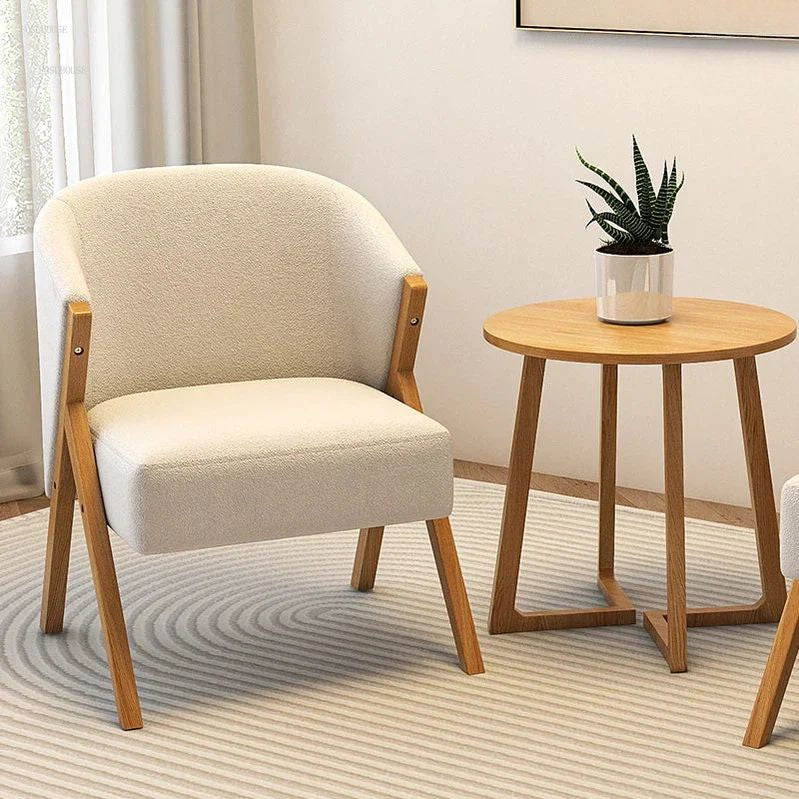 Beige armchair and wooden side table with a plant in a living room setting