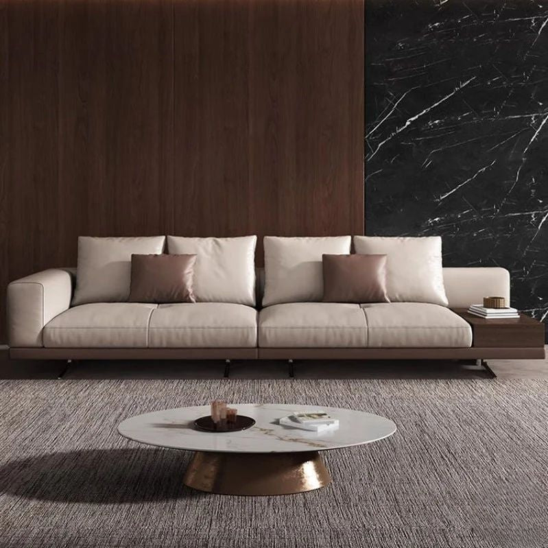 "Philips Modern Modular Puffy Style Sofa With One Sided Wooden Armrest. Modern beige sofa with brown cushions in a stylish living room setting."