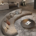 Modern living room with a curved beige sofa and round coffee table.