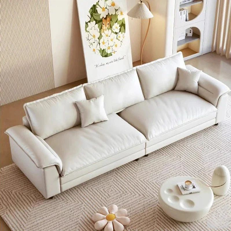 White sofa in a living room with a small table and decorative items. Nordic style sofa, minimalist sofa design, aesthetic modern sofa design, living room furniture. 