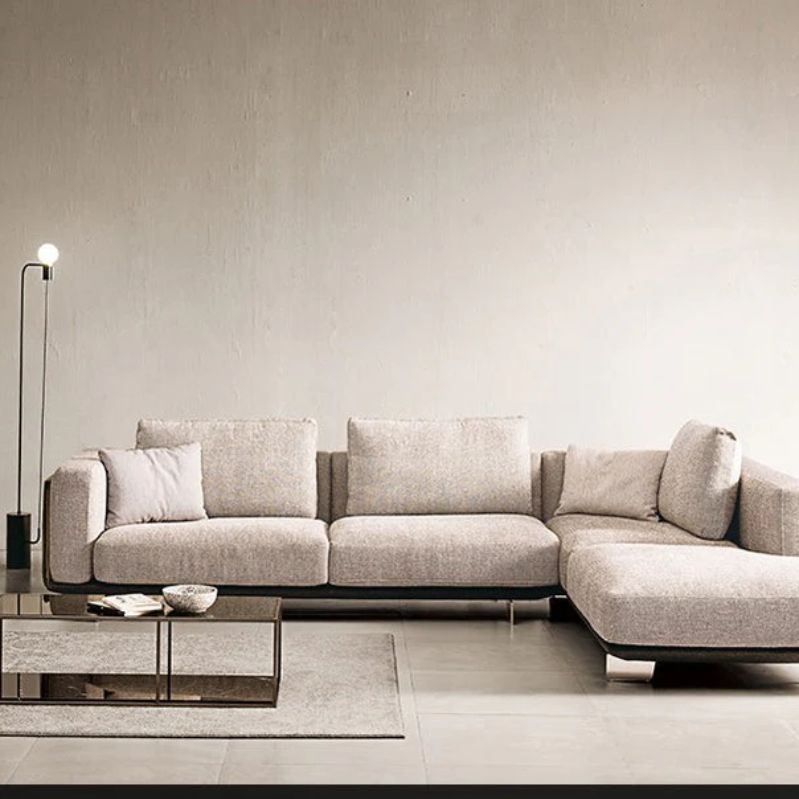 "Philips Modern Vanessa Luxury Sofa Style -Gray sectional sofa in a minimalistic living room with a lamp and coffee table."