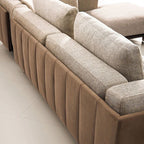 "Sectional sofa with beige and brown cushions on a light-colored floor."