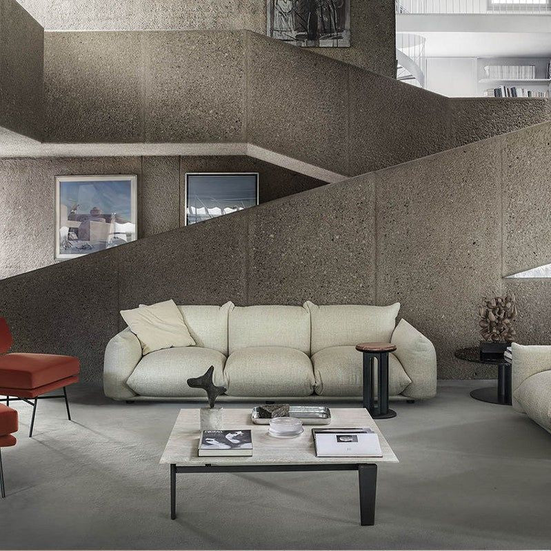 "Puffy European Style 3-Seater Sofa. Modern living room with a beige sofa, coffee table, and decorative items."