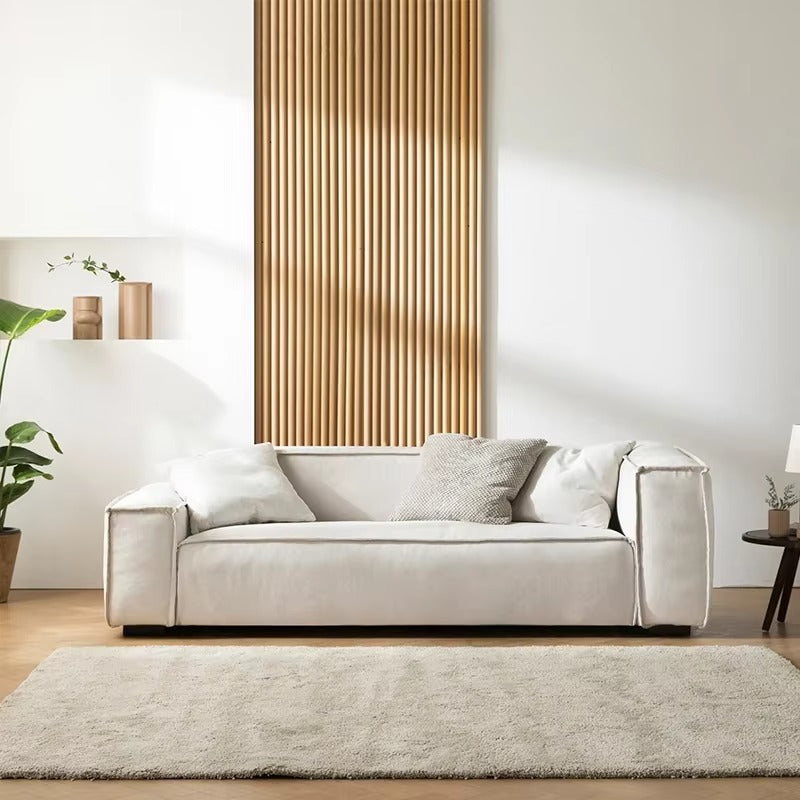 Modern living room with a beige sofa, wooden wall panel, and decorative elements. Sleeper sofa, sectional sofa, Living spaces. 