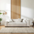 Modern living room with a beige sofa, wooden wall panel, and decorative elements. Sleeper sofa, sectional sofa, Living spaces. 