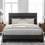 Gray upholstered bed with white bedding in a bright bedroom. Minimalist bedframe, upholstered bed, bedroom furniture.