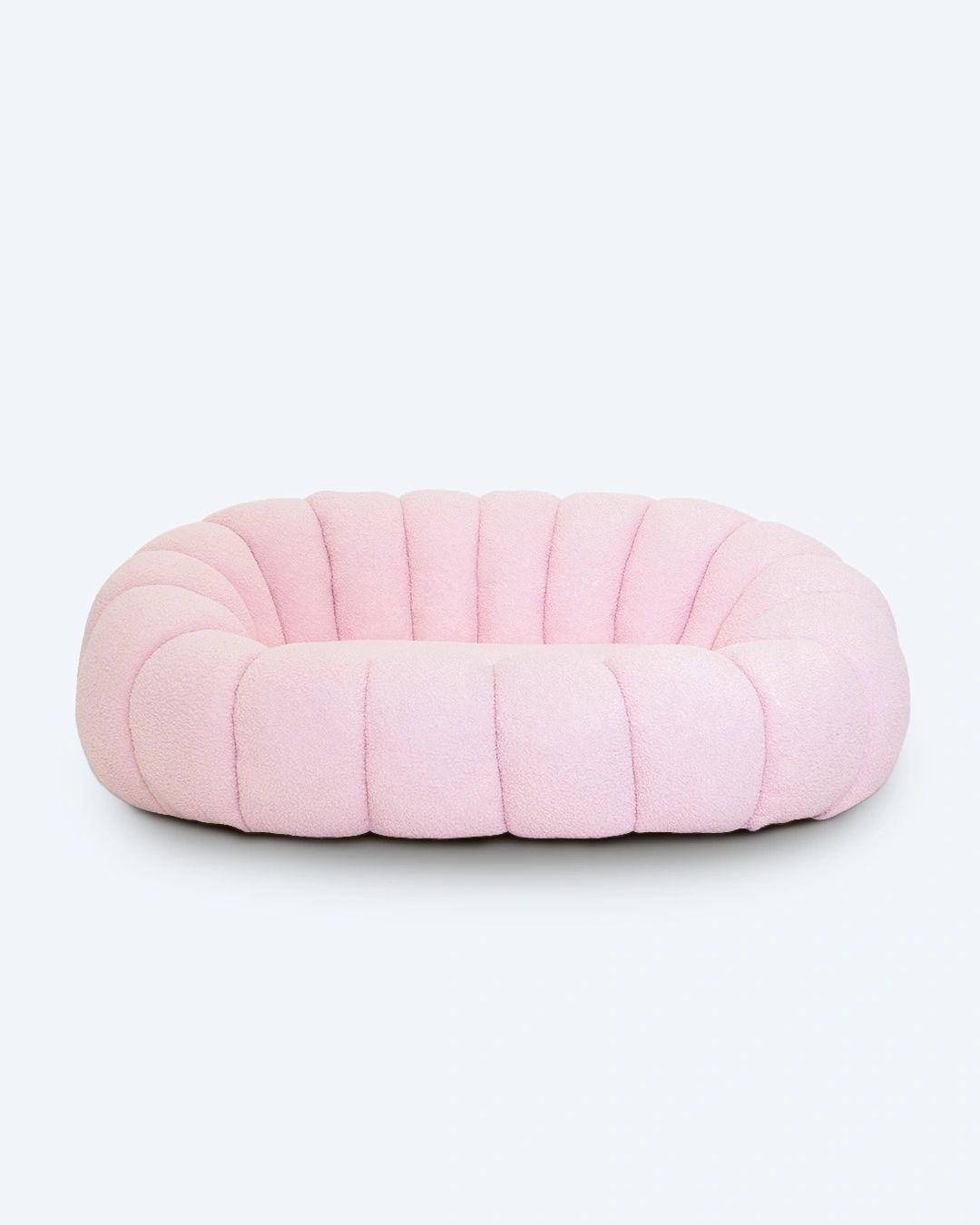 Pink quilted pet bed on a white background. Minimalist furniture, cloud sofa, sleek style sofa, trending sofa design. 