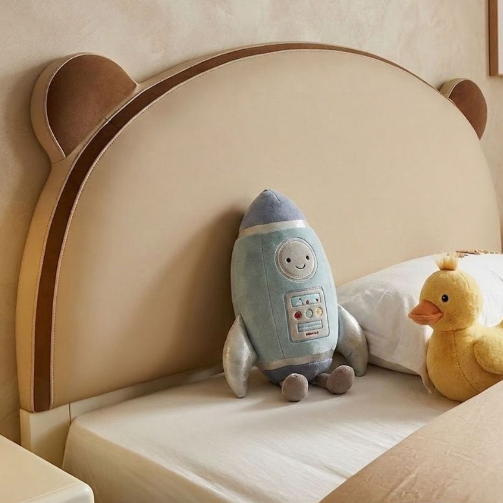 Close-up of the Arched Heirloom Bear Bedframe headboard featuring two-tone upholstery and soft bear-ear detailing