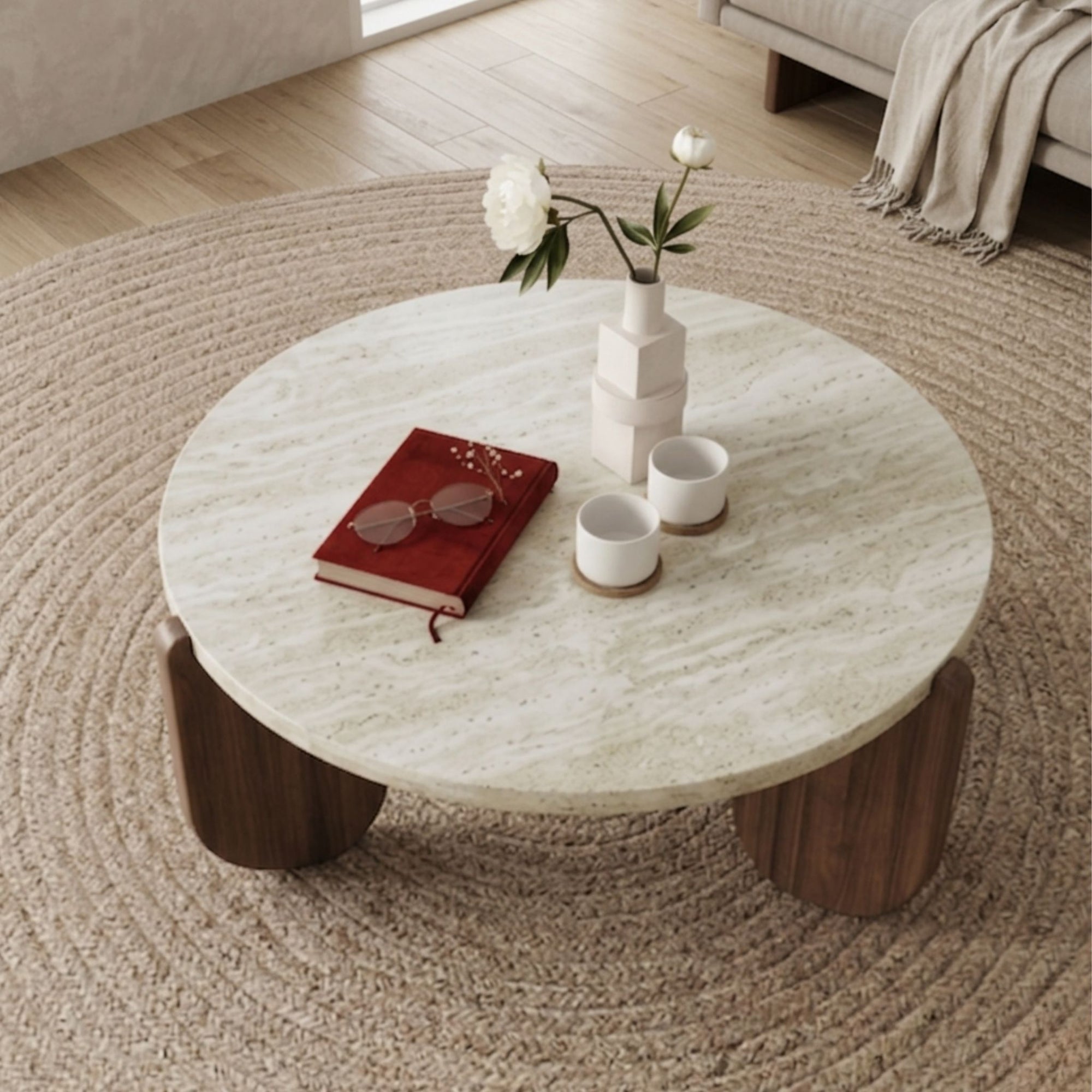 A close-up perspective of the Terra Marble Occasional Coffee Table highlighting the organic texture of the travertine stone top and the curved sculptural wood supports